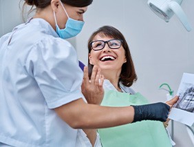 Dentist reviewing X-ray with smiling patient