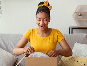 Woman in yellow shirt opening box