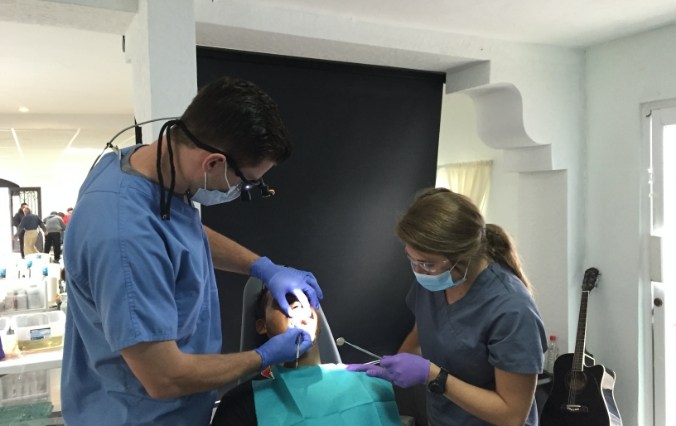 Dentist and team member treating dental patient