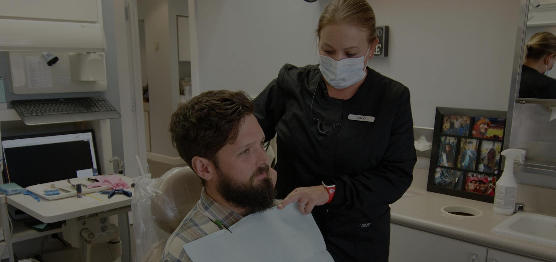 Dental team member placing protective sheet over patient's clothes