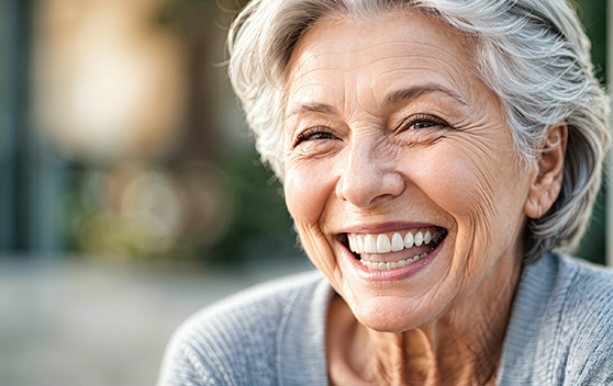 Woman smiling over the cost of dentures in Broken Arrow