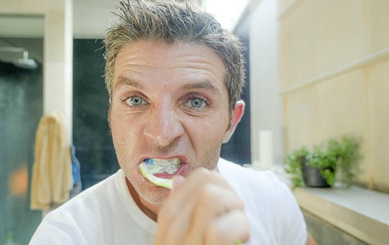 Man brushing his dental implants in Broken Arrow