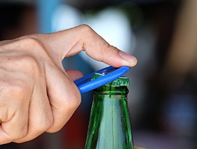 Man opening a bottle with bottle opener