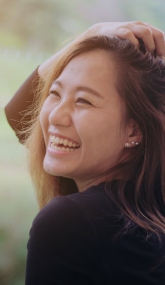 Smiling woman with her hand on top of her head