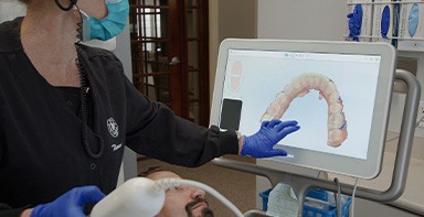 Dental team member in Broken Arrow taking digital impressions of a patient's teeth