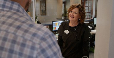 Broken Arrow dental team member talking to patient at front desk