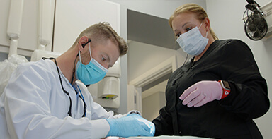 Dentist and team member treating a Broken Arrow dental patient