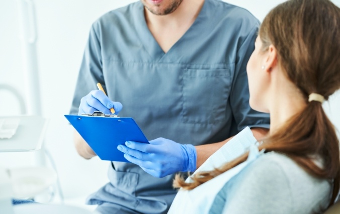 Dentist and patient reviewing dental insurance forms