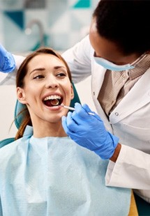 a patient getting her teeth checked by her dentist