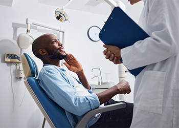Man in the dental chair smiling while he talks to his sedation dentist in Broken Arrow