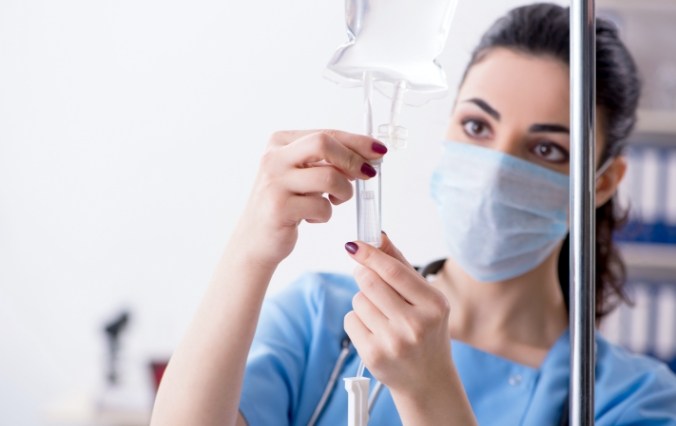 Dental team member setting up I V sedation dentistry drip