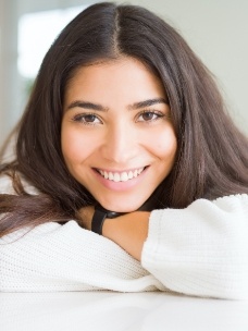 Woman sharing aligned smile after Invisalign treatment