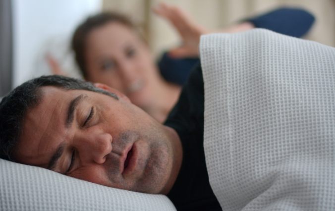 Woman frustrated next to snoring man in need of sleep apnea treatment