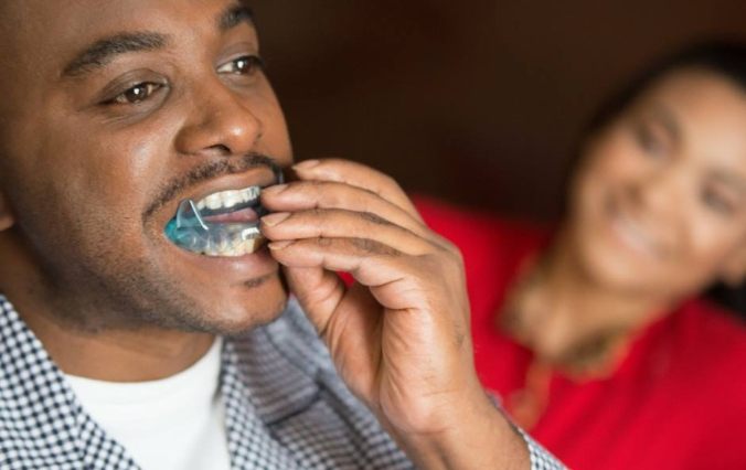 Man placing sleep apnea treatment appliance