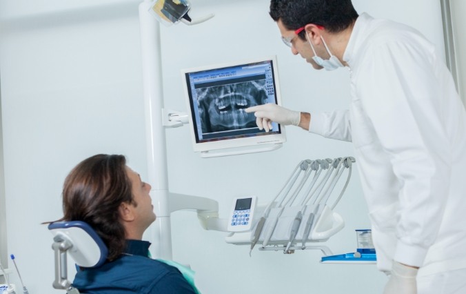 Dentist and patient looking at digital x-rays