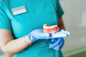 Dentist holding full dentures for the lower arch