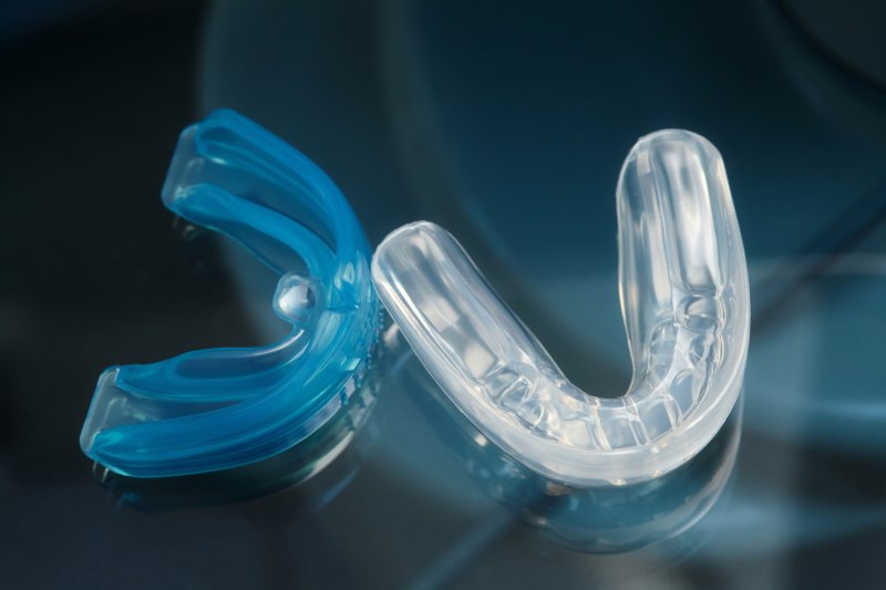 A blue and clear mouthguard laying side by side