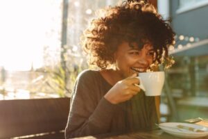Woman smiling and drinking coffee. 